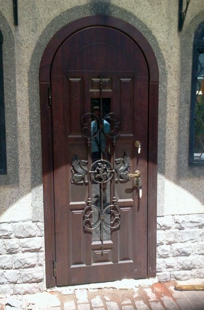 Арочная входная дверь ЛД-714 с ковкой и окном